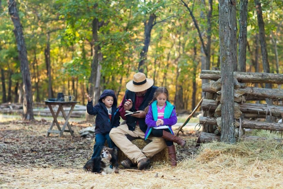 Costumed reenactors gathered in the autumn woods at the village